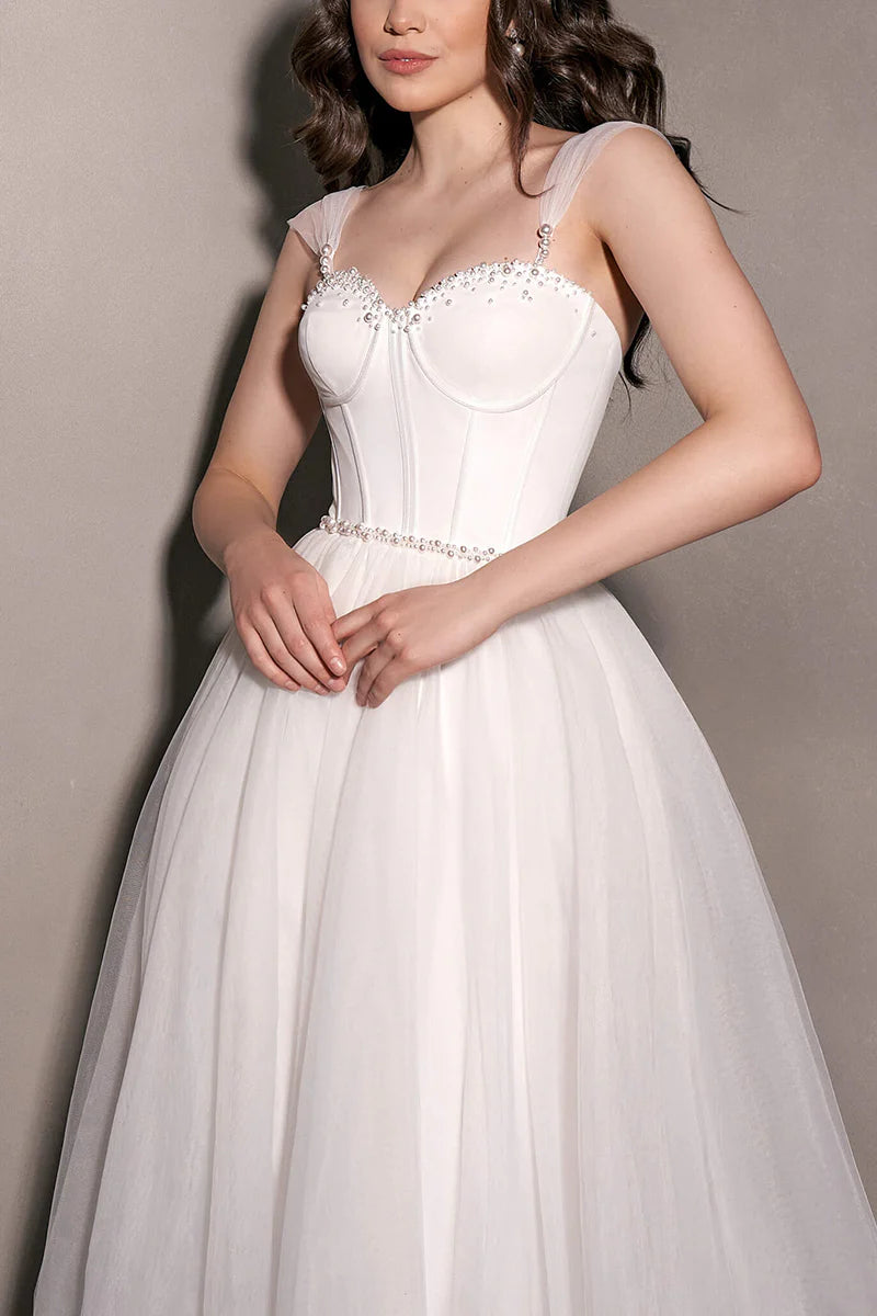 Abito da sposa minimalista trasparente con scollo a cuore e perle